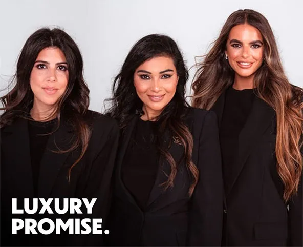 Three women in black blazers posing